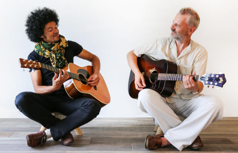Joel Rabesolo and Fabien Degryse playing guitars together.